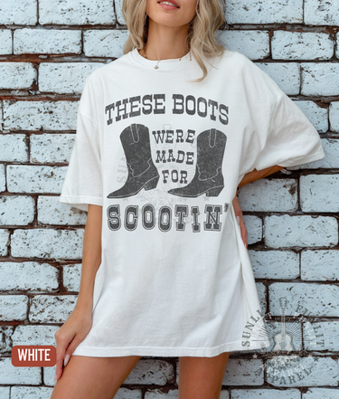 A woman wearing a white t-shirt with a graphic design of a pair of boots and the text